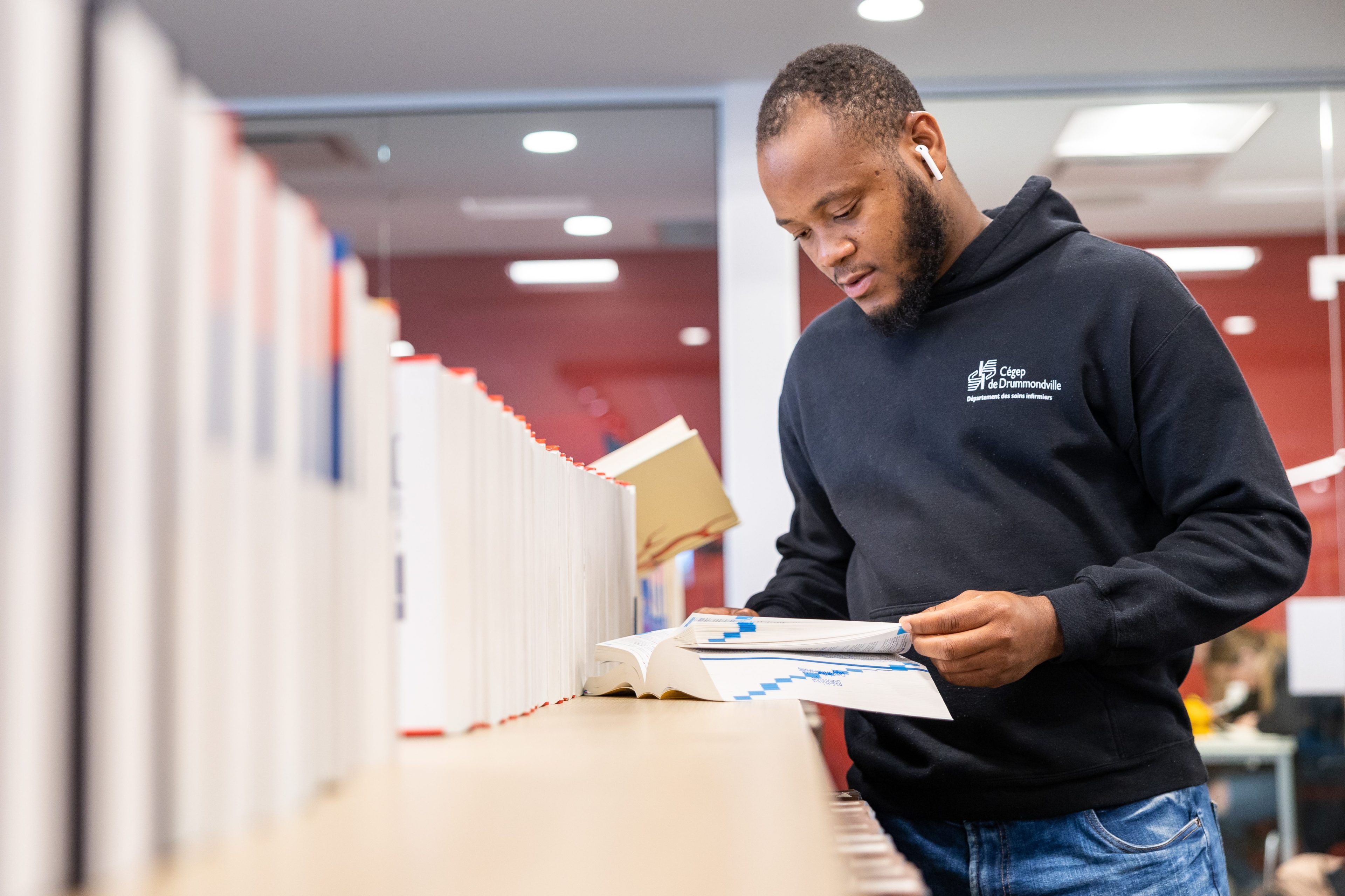 Étudiant dans le Cégep consultant un livre